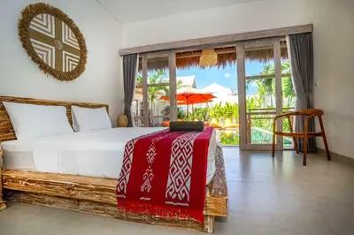 a bedroom with a bed with a red blanket on it at Villa Vaimala 4BR Pool Tropical Home Seminyak in Seminyak
