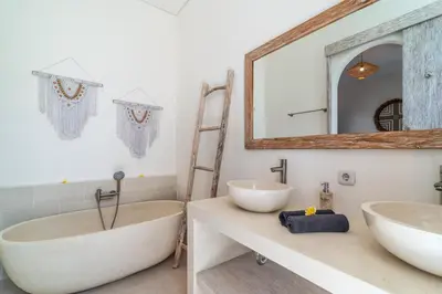 a bathroom with two sinks and a tub and a mirror at Villa Vaimala 4BR Pool Tropical Home Seminyak in Seminyak
