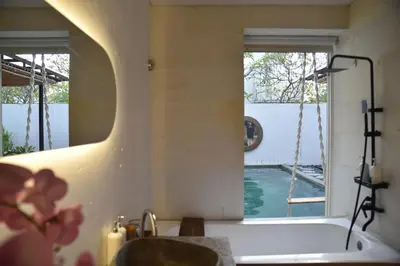 a bathroom with a bath tub and a window at Casa Nakoa 2BR With Private Pool in Nusa Dua