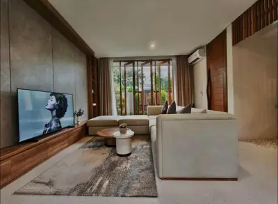 a living room with a couch and a flat screen tv at Villa Mirana in Seminyak