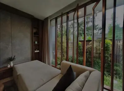 a living room with a couch and a large window at Villa Mirana in Seminyak