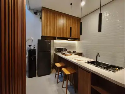 a kitchen with a sink and a counter with stools at Villa Mirana in Seminyak