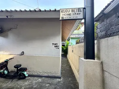 a scooter parked next to a garage with a sign at Kubu Betel Home Stay in Canggu