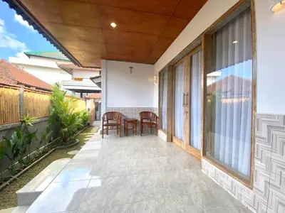 a patio with a table and chairs on it at Kubu Betel Home Stay in Canggu
