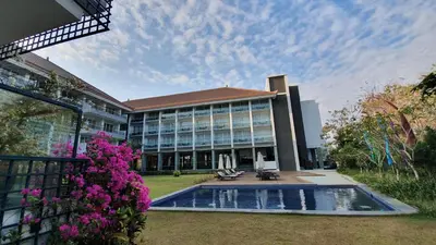 a building with a swimming pool in front of it at The Sintesa Jimbaran Bali in Jimbaran