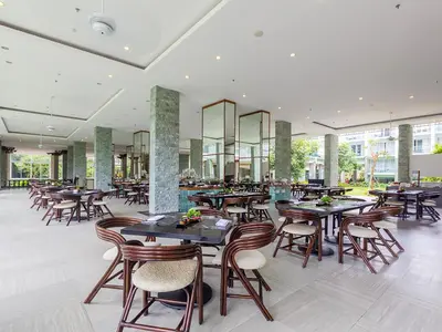 a restaurant with tables and chairs in a building at The Sintesa Jimbaran Bali in Jimbaran