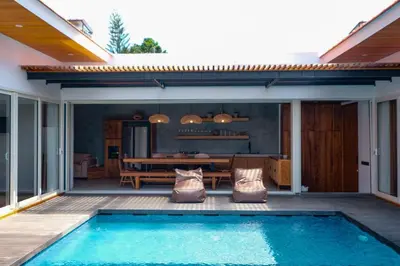 a house with a swimming pool on a patio at Anama Villa Kerobokan in Seminyak