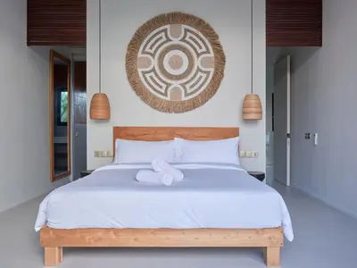 a bedroom with a white bed with a stuffed animal on it at Villa Papaya Luxurious4bd Umalas in Canggu