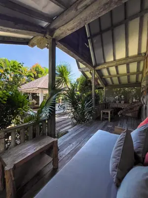 a wooden porch with a bench on a deck at Luxurious 5Br Retreat in Umalas in Canggu