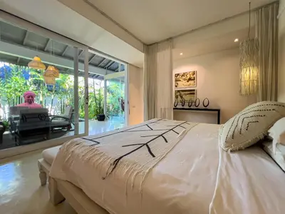 a bedroom with a large bed and a large window at Luxurious 5Br Retreat in Umalas in Canggu