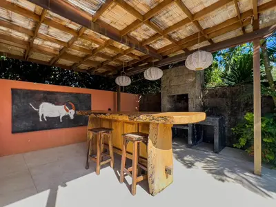 an outdoor dining area with a wooden table and stools at Luxurious 5Br Retreat in Umalas in Canggu