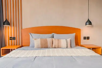 a bedroom with a bed with a wooden headboard at Villa Cek Ombak 2 Canggu in Canggu