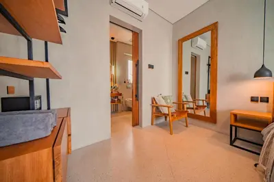 a living room with a table and a chair and a mirror at Villa Cek Ombak 2 Canggu in Canggu