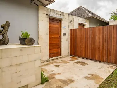 a house with a wooden gate and a patio at tuluscolivingseminyakvilla2 in Seminyak