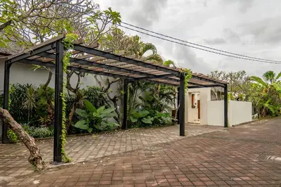 a pergola with plants on the side of a building at tuluscolivingseminyakvilla2 in Seminyak