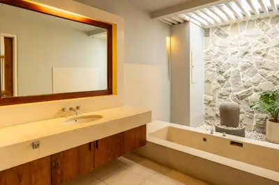 a bathroom with a sink and a tub and a mirror at tuluscolivingseminyakvilla2 in Seminyak