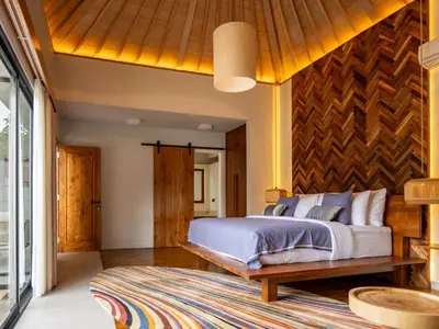 a bedroom with a bed and a wooden wall at tuluscolivingseminyakvilla2 in Seminyak