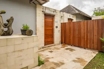 a house with a wooden gate and a patio at tuluscolivingseminyakvilla3 in Seminyak