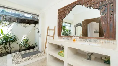 a bathroom with a sink and a large mirror at Gembira Villa Seminyak in Canggu