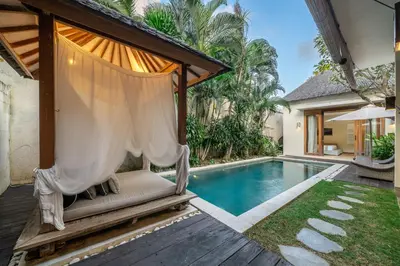 a hammock by a swimming pool in a villa at Le Chloe Villa Seminyak in Seminyak