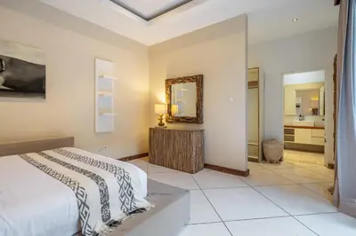 a bedroom with a bed and a mirror at Le Chloe Villa Seminyak in Seminyak