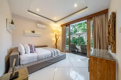 a bedroom with a bed and a large window at Le Chloe Villa Seminyak in Seminyak