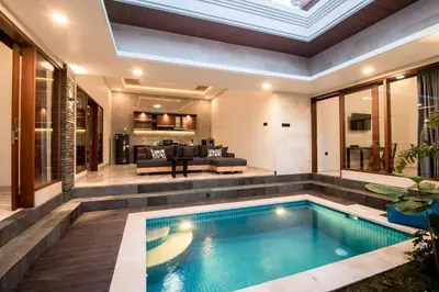 an infinity pool in a house with a living room at Villa Sakura III Seminyak in Seminyak