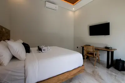 a bedroom with a bed with a cat sitting on it at Villa Sakura III Seminyak in Seminyak