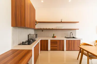 a kitchen with wooden cabinets and a counter top at Villa Litan Seminyak - 3 Bedroom Villa in Seminyak
