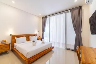 a bedroom with a bed and a large window at Villa Litan Seminyak - 3 Bedroom Villa in Seminyak