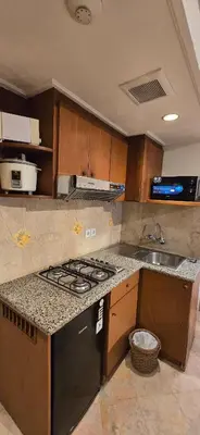 a kitchen with a stove and a sink at The Palmana Courtyard Jayakarta Residence 4 in Seminyak