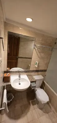 a bathroom with a sink and a toilet and a mirror at The Palmana Courtyard Jayakarta Residence 6 in Seminyak