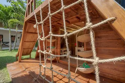 a small wooden house with a net at Incredible Family villa with water slide Beachside in Sanur