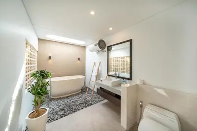 a bathroom with a tub and a sink and a toilet at Modern 3BR Villa Private Pool Serangan Beach in Pulau Serangan