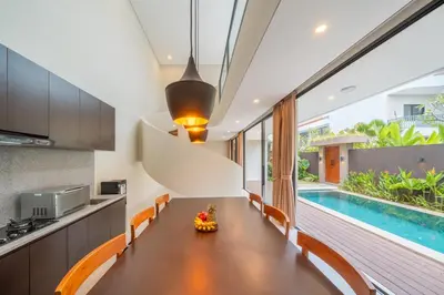a kitchen and dining room with a table and a swimming pool at Modern 3BR Villa Private Pool Serangan Beach in Pulau Serangan