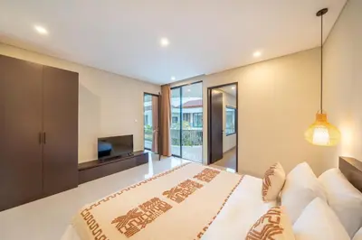 a bedroom with a large bed and a television at Modern 3BR Villa Private Pool Serangan Beach in Pulau Serangan