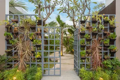 a garden with plants on a blue trellis at Modern 3BR Villa Private Pool Serangan Beach in Pulau Serangan