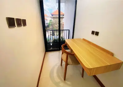 a table and a chair in a room with a window at Villa Casanomi By Pandara in Kerobokan