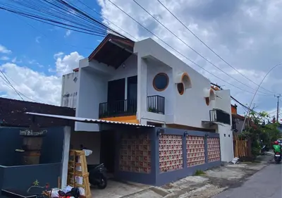 a white house with a blue fence in front of it at Villa Casanomi By Pandara in Kerobokan