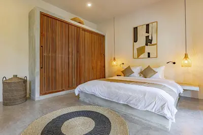 a bedroom with a large bed and a large window at Villa Surga Kecil Seminyak in Seminyak