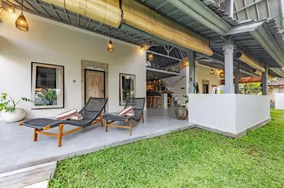 an outdoor patio with two chairs and a table at Villa Surga Kecil Seminyak in Seminyak