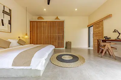 a bedroom with a large bed and a desk at Villa Surga Kecil Seminyak in Seminyak
