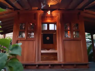 a wooden cabinet with glass doors and a window at Desa Biasa in Kerobokan