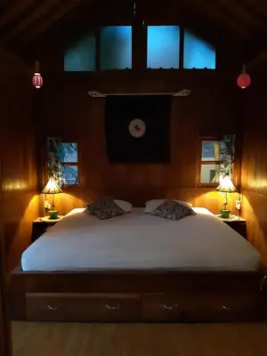 a bedroom with a large white bed with two lamps at Desa Biasa in Kerobokan