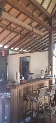 a kitchen with a bar with chairs and a counter at Desa Biasa in Kerobokan