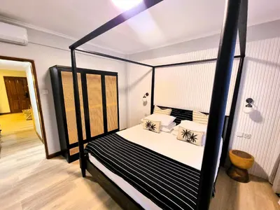 a bedroom with a black and white canopy bed at Mana Suites Bali in Kuta