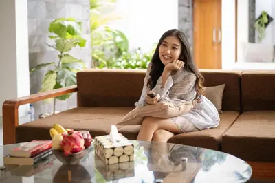a young girl sitting on a couch in a living room at Vansari Serenity Villa in Seminyak