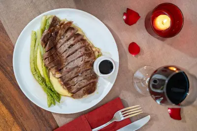 a plate of food with a piece of meat and asparagus at Vansari Serenity Villa in Seminyak