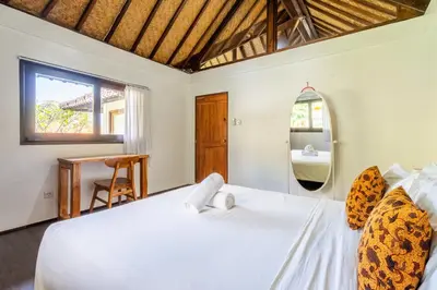 a bedroom with a bed and a mirror at Bali Dream Villa Legian by iBali Management in Seminyak