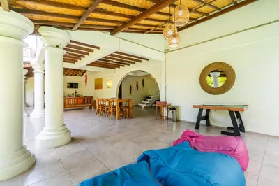 a large room with columns and a table and chairs at Bali Dream Villa Legian by iBali Management in Seminyak